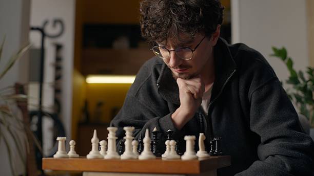 istock Contemplative Caucasian guy player grandmaster playing chess board game at home pensive smart male moving pawn piece chessboard thinking man pondering strategy gaming tactics preparing for tournament 2223801550