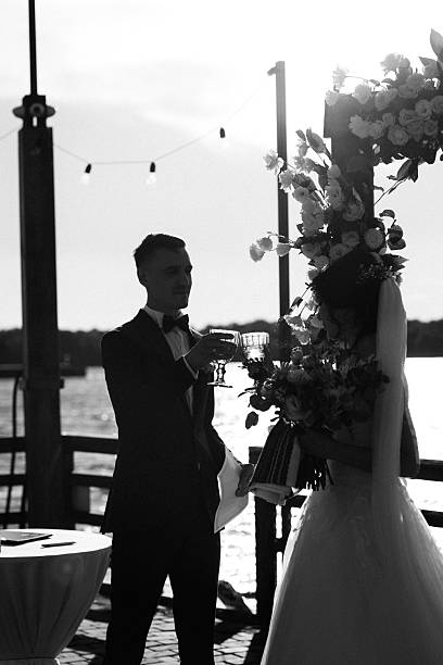 wedding ceremony on a high pier near the river with invited guests
