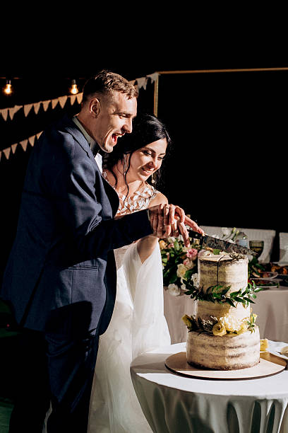 istock newlyweds happily cut and taste the wedding cake 2223801973
