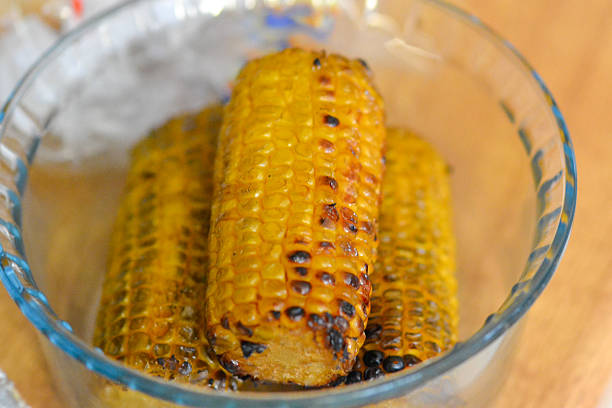 Charred and juicy grilled corn on the cob, a staple of Finnish summer barbecues. Served in a glass dish, this simple yet delicious vegetable side dish is a favorite in Finnish outdoor cooking.