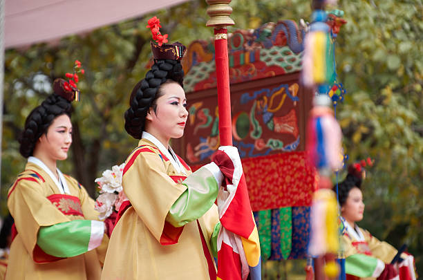 Seoul, South Korea - September 29, 2012: Two performers in richly adorned hanbok carry a ceremonial banner during the royal parade reenactment held at Unhyeongung Royal Residence as part of the Chuseok Traditional Performing Arts Festival.