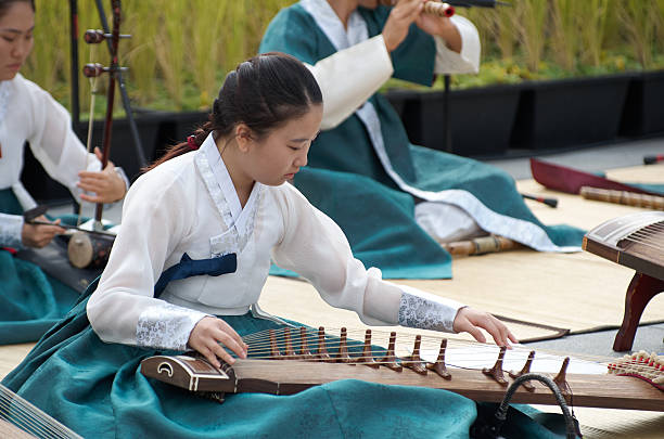 Seoul, South Korea - September 30, 2012: A young musician performs on the gayageum, a traditional Korean string instrument, at the Chuseok Traditional Performing Arts Festival in Gwanghwamun Square, showcasing Korea's rich musical heritage.