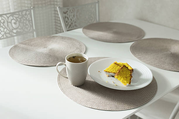 Breakfast. Cup of tea on table. Sweet dessert on a plate