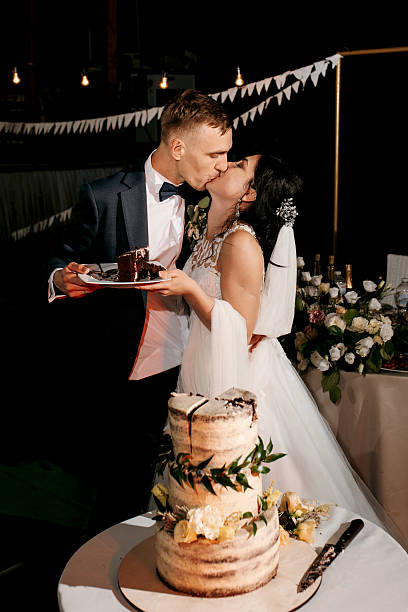 istock newlyweds happily cut and taste the wedding cake 2223805239
