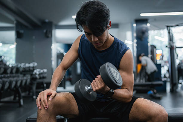 istock Fit Man Lifting Weights During an Intense Workout Session at the Gym 2223805682
