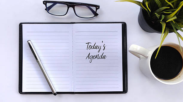 istock Today's Agenda Notebook, Coffee, Alarm Clock, and Eyeglasses on White Background 2223807460