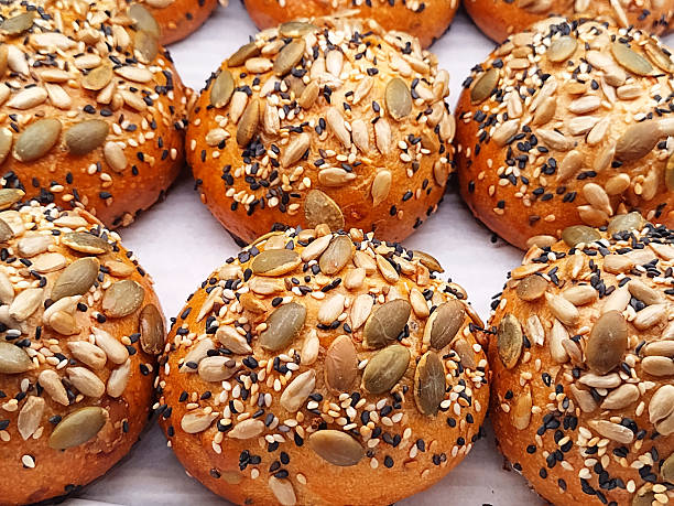 A delightful collection of golden brioche buns, generously encrusted with a vibrant mix of sesame, pumpkin, and sunflower seeds for added texture and flavor, Brioche multi-seed.