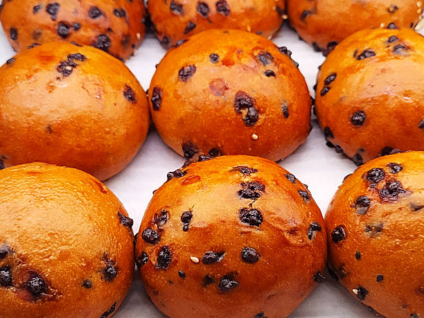 Decadent golden brioche buns, generously studded with rich, dark chocolate chips, promising a truly delightful and indulgent sweet treat, Brioche chocco.