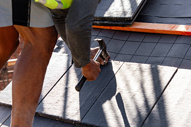 istock Builder carefully places roof tiles on a sloped surface while standing on top of a building showcasing the effort involved in roofing work 2223812708