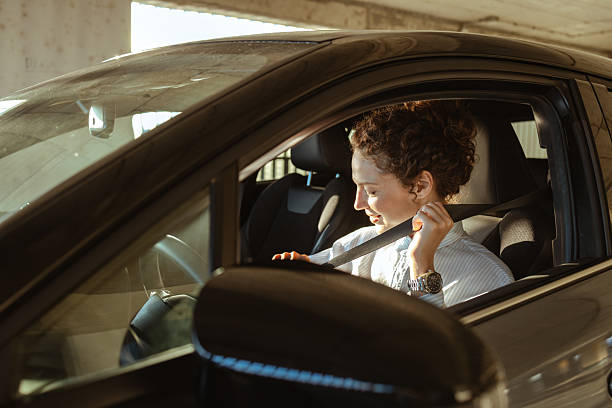 istock Woman fastening seatbelt while sitting in a modern car interior 2223813065