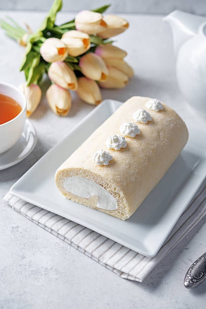 Vanilla cake roll with whipped cream filling in a plate