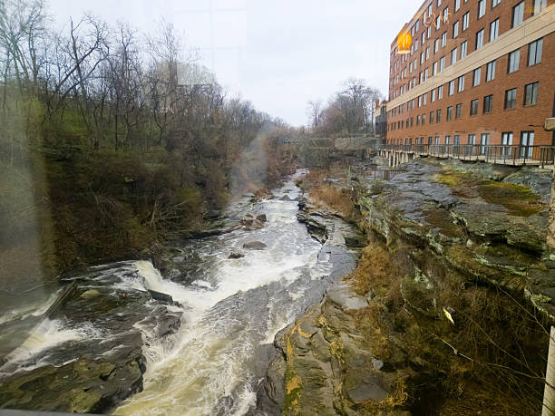 Cuyahoga River flows alongside historic building on a cloudy day