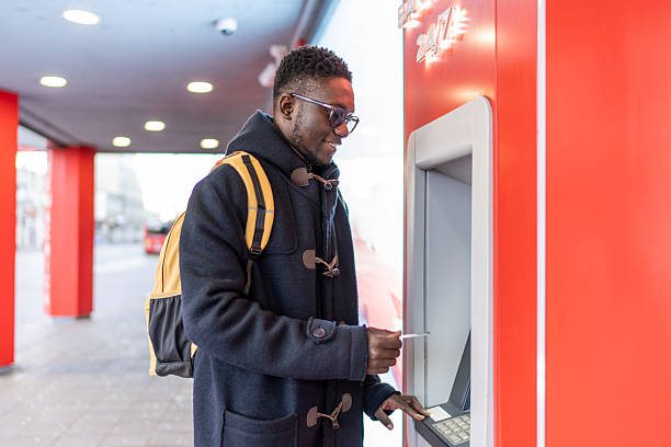 istock Young adult using atm for banking transaction 2223818017