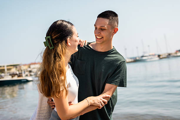 istock Happy Young Couple Hugging and Smiling on the Beach 2223820011