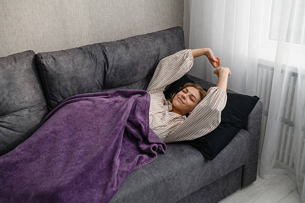 istock Young woman stretching in bed after waking up at home. 2223822018