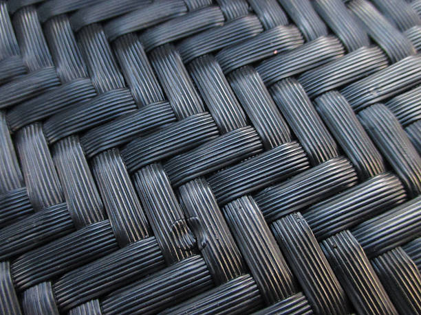 two wooden outdoor chairs with black woven seats, in the style of wicker and leather, using industrial materials, in an outdoor setting, made of wood, with modernist-inspired elements, in navy blue and amber