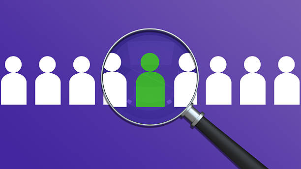 A magnifying glass highlights a unique green Icon from a crowd of figures, symbolizing the Recruitment process and Headhunting - Recruitment. This powerful visual represents Finding the right Employee and recognizing Individuality and potential. It's an ideal Concept for Human Resources, illustrating the Focus - Concept and Scrutiny required to build a strong team and identify future Leadership.