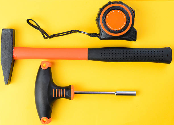 istock Tape measure, hammer and socket holder on yellow background, top view tools 2223825925