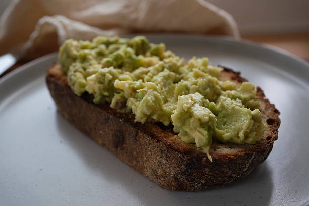 istock Slice of sourdough toast topped with mashed ripe avocado. 2223827307