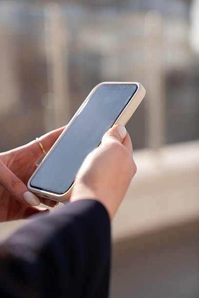 istock Close up or woman using smart phone. Hand holding smartphone with black screen 2223828836