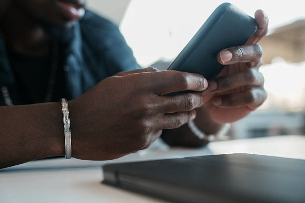 istock Close up or black man using smart phone. Hand holding smartphone 2223828971