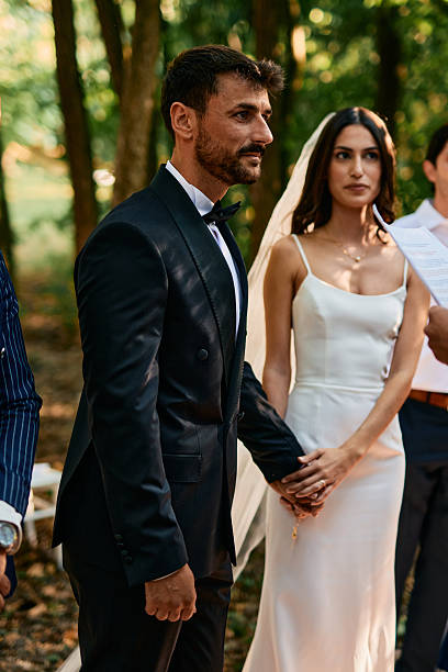 istock Bride and groom holding hands during wedding ceremony in the woods 2223832466