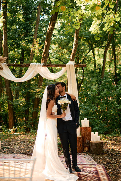 istock Romantic Couple Exchanging Affectionate Kiss at Forest Wedding Ceremony 2223832481