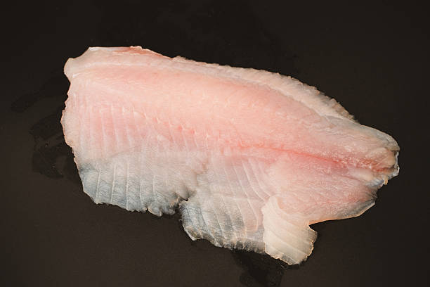 istock Fresh tilapia fillet on black background, top view. 2223832605