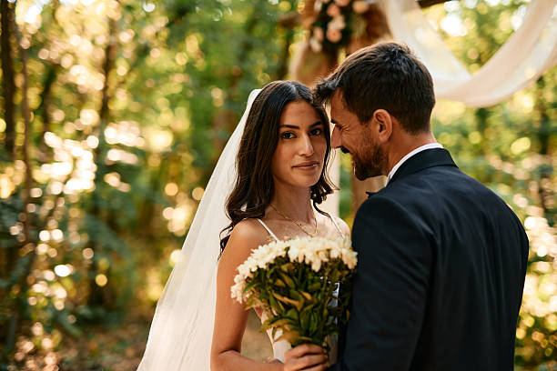 istock Bride and groom looking at each other during wedding ceremony in the forest 2223833052