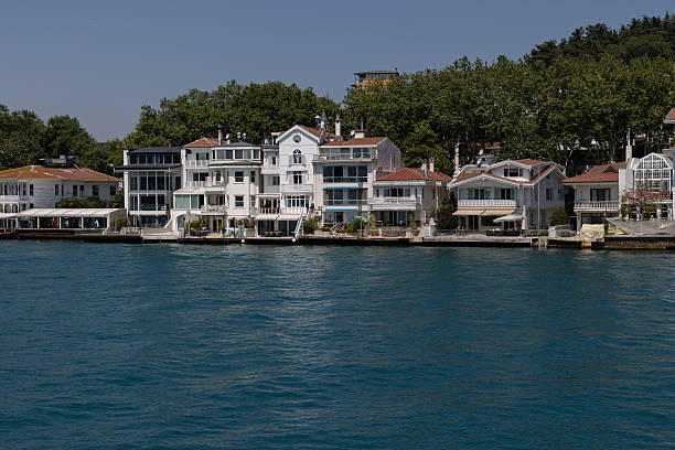 Istanbul, Turkey - July 12, 2025: Historic waterfront buildings and small boats along the Bosphorus coast between Istinye and Buyukdere in Istanbul.
