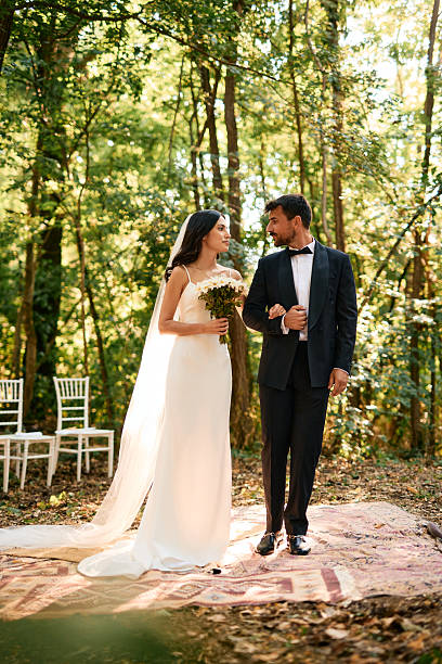 istock Bride and groom looking at each other during wedding ceremony in the forest 2223833309