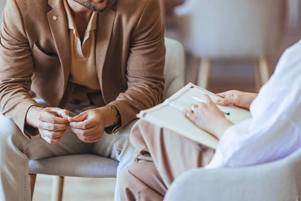 istock Man Expressing Thoughts in a Counseling Session with a Therapist Writing Notes 2223837784