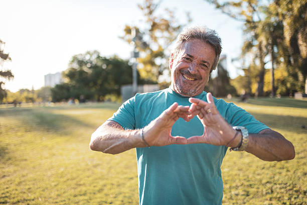 istock Senior man showing heart shape with hands in the park 2223837988