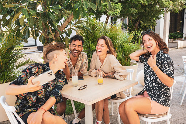 istock Cheerful friends taking selfie and laughing together at a bar table 2223838120