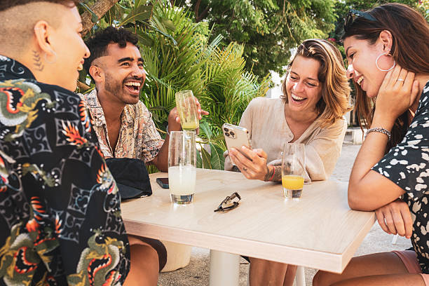 istock Friends laughing together while looking at smartphone at outdoor cafe 2223838121