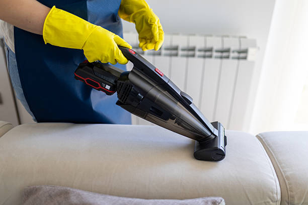 istock Homeowner using a handheld vacuum cleaner to clean sofa upholstery during a spring cleaning session indoors 2223840532