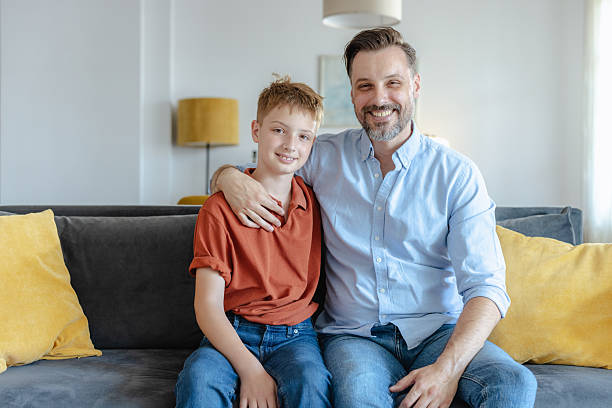 istock Father and son sitting together on a comfortable living room sofa 2223840632