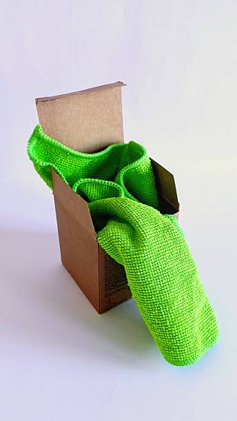 Green kitchen towel in a brown cardboard small box.
