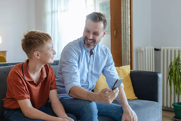 istock Father and son bonding while looking at a smartphone on the couch 2223840843
