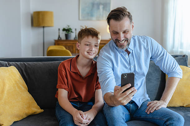 istock Father and son bonding while looking at a smartphone on the couch 2223840845