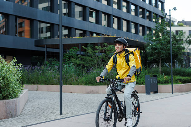 istock Courier on a bicycle delivering packages in an urban environment 2223843371