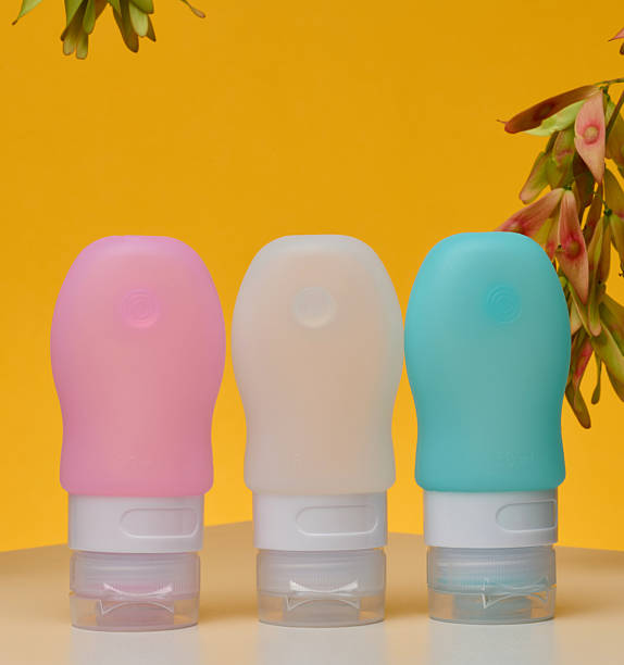 istock Three soft silicone travel cosmetic bottles stand on white surface. Yellow background 2223847107