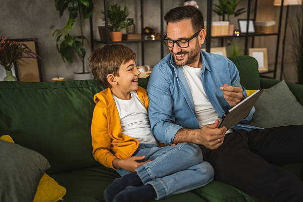 istock Father with eyeglasses and son use tablet for homework browse internet 2223849582