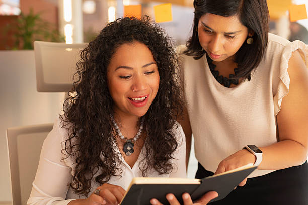 istock Two women in an office, speak animatedly about the work they must play while checking some notes 2223851259