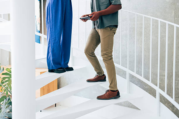 istock Two People Ascending a Modern Indoor Staircase in Stylish Attire 2223853441