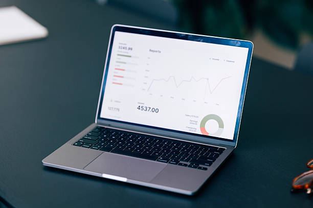 Open laptop showing financial data insights and graphs placed on a desk, conveying a professional analysis environment. Ideal for business, technology, and corporate-related themes.