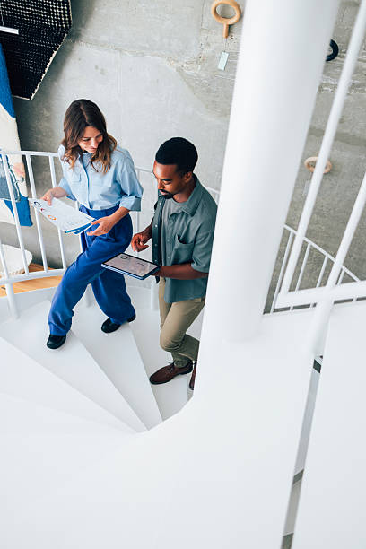 istock Business Colleagues Discussing Work While Ascending a Modern Spiral Staircase 2223853449