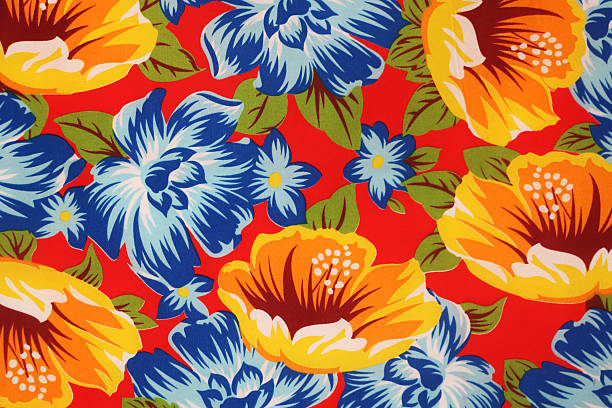 This is a vibrant, full-frame close-up of a floral fabric pattern featuring large orange and blue flowers with green leaves against a bright red background.