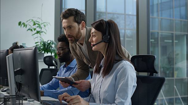 istock Call center inspection multiethnic operators working online consulting helpline customer support at office Caucasian boss checking business work success talking coworkers Indian African agents headset 2223860916