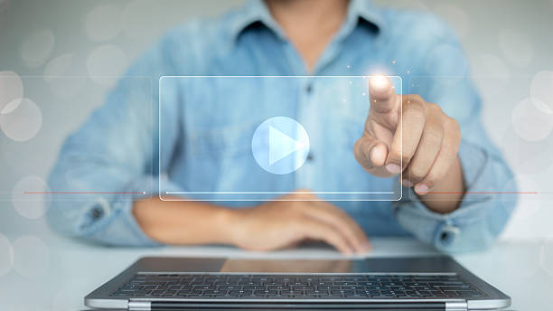 istock Man pressing virtual play button on laptop screen, representing digital video streaming, online media content, and e-learning technology for business and education. 2223863022